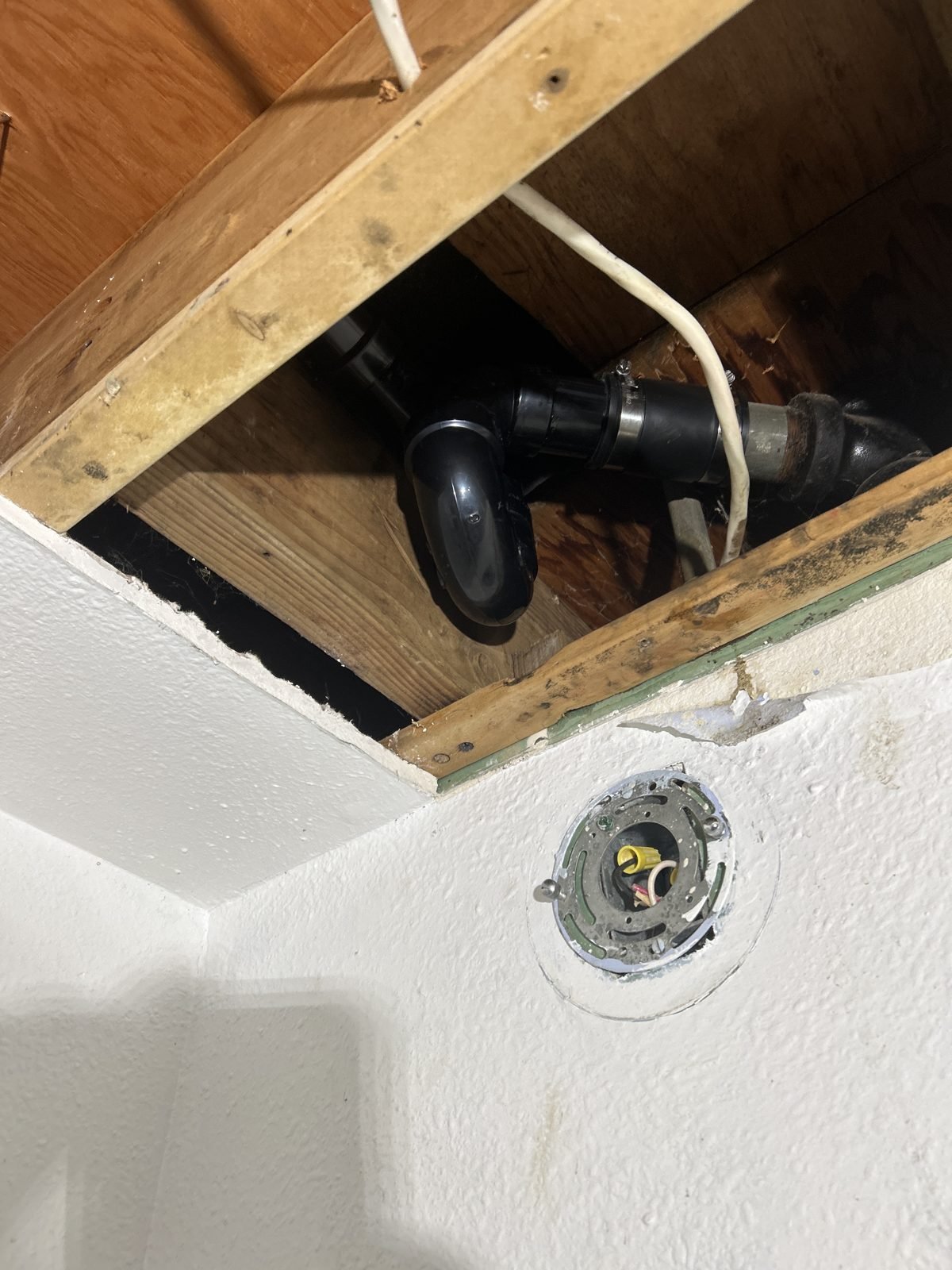 New black ABS waste and overflow assembly installed under the tub